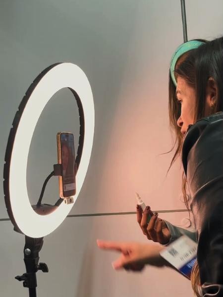 A creator recording with a phone and a ring light